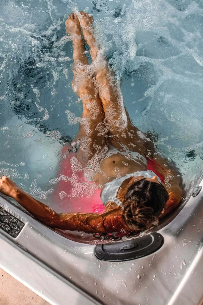 a woman in a backyard hot tub
