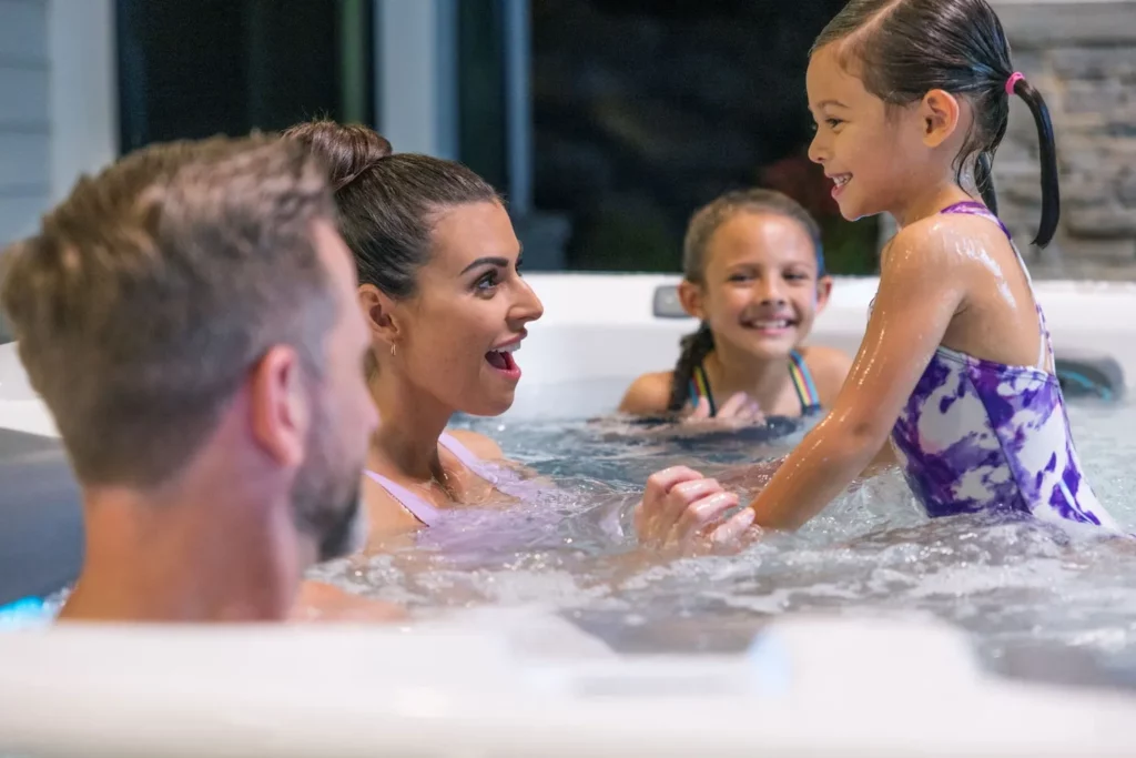 a family of four in a backyard hot tub